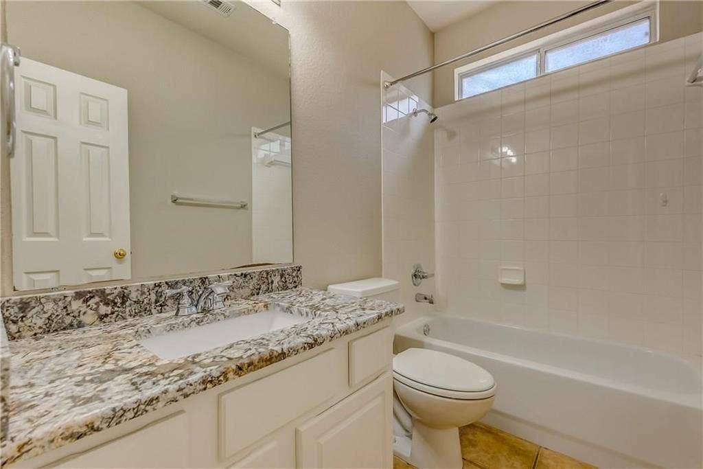 2300 Reston Drive, McKinney, TX 75072 Full bathroom with tiled shower / bath, toilet, tile flooring, and vanity