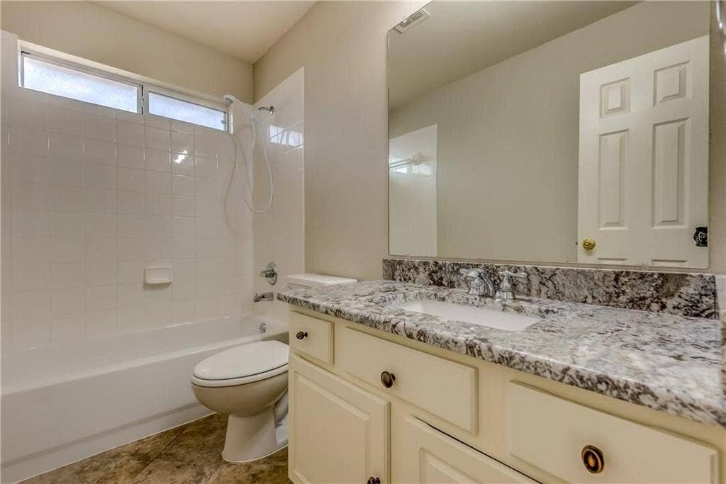 2300 Reston Drive, McKinney, TX 75072 Full bathroom featuring toilet, vanity with extensive cabinet space, tiled shower / bath, and tile flooring