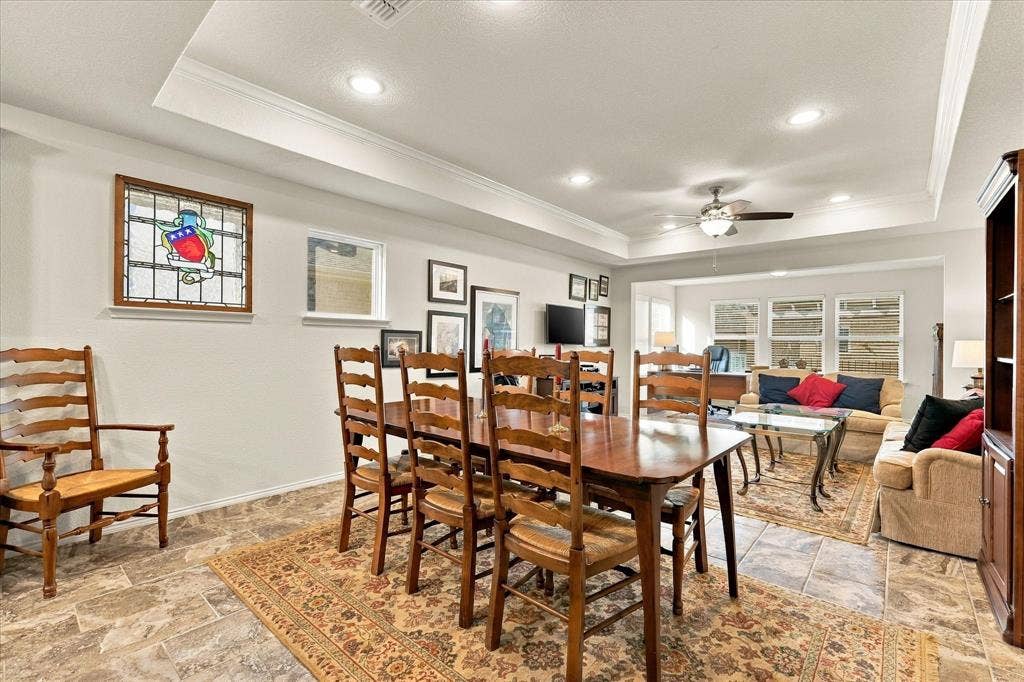 Tray ceiling with recessed lighting, tile flooring, and decorative stained-glass window insert