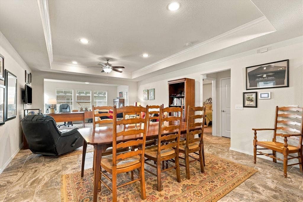 Tray ceiling with recessed lighting, stone-finish tile flooring, and ceiling fan