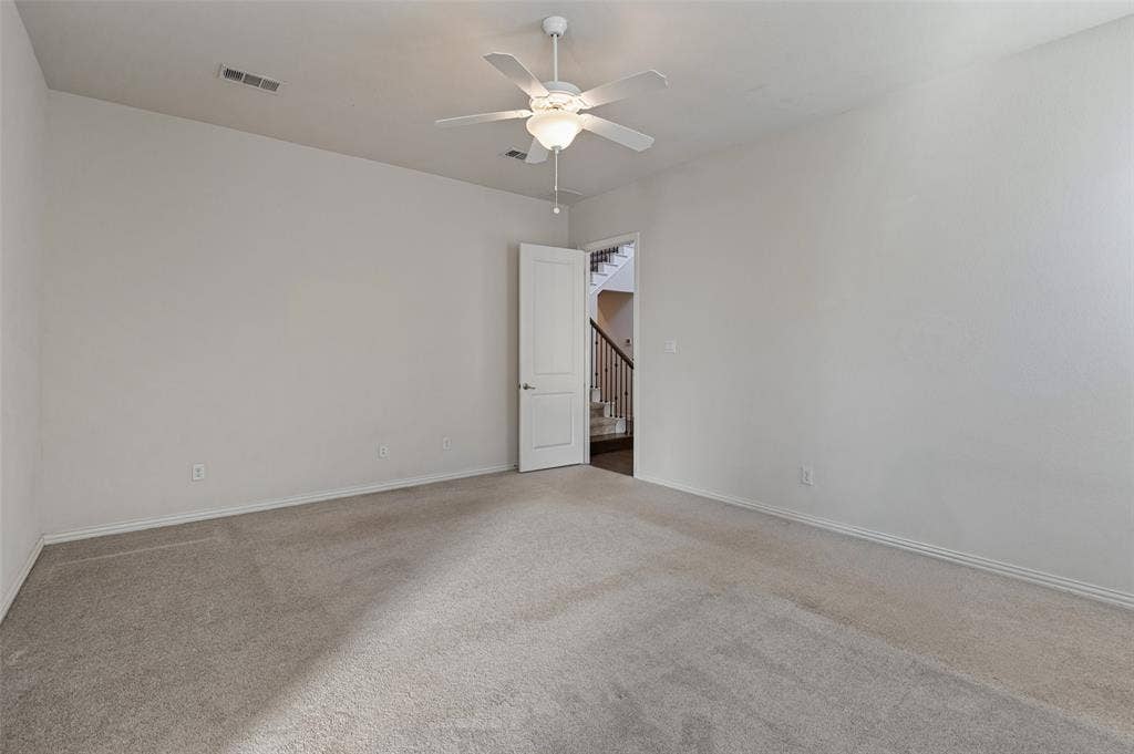 Room featuring neutral wall tones, wall-to-wall carpeting, and a ceiling fan with integrated lighting
