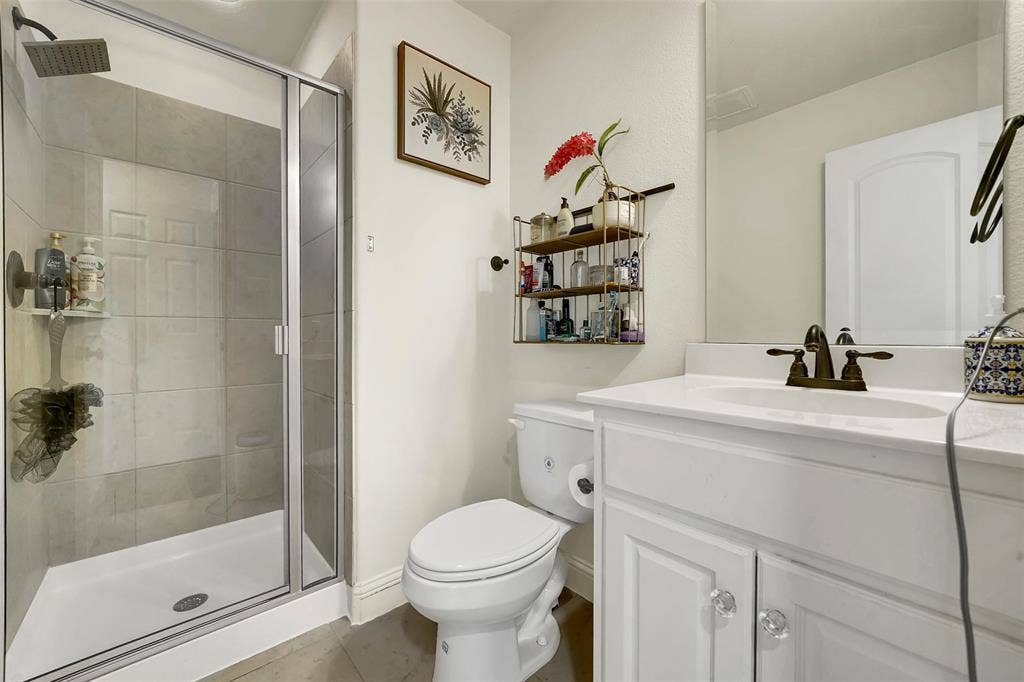 302 Torch Lily Lane, Wylie, TX 75098 Shower enclosure with clear glass door, tile surround, and square shower head