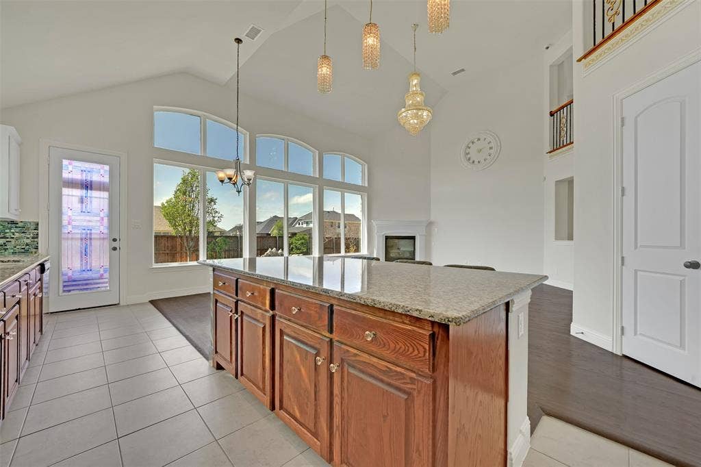 302 Torch Lily Lane, Wylie, TX 75098 Kitchen island with a light-toned countertop, wood cabinetry, and a tile floor