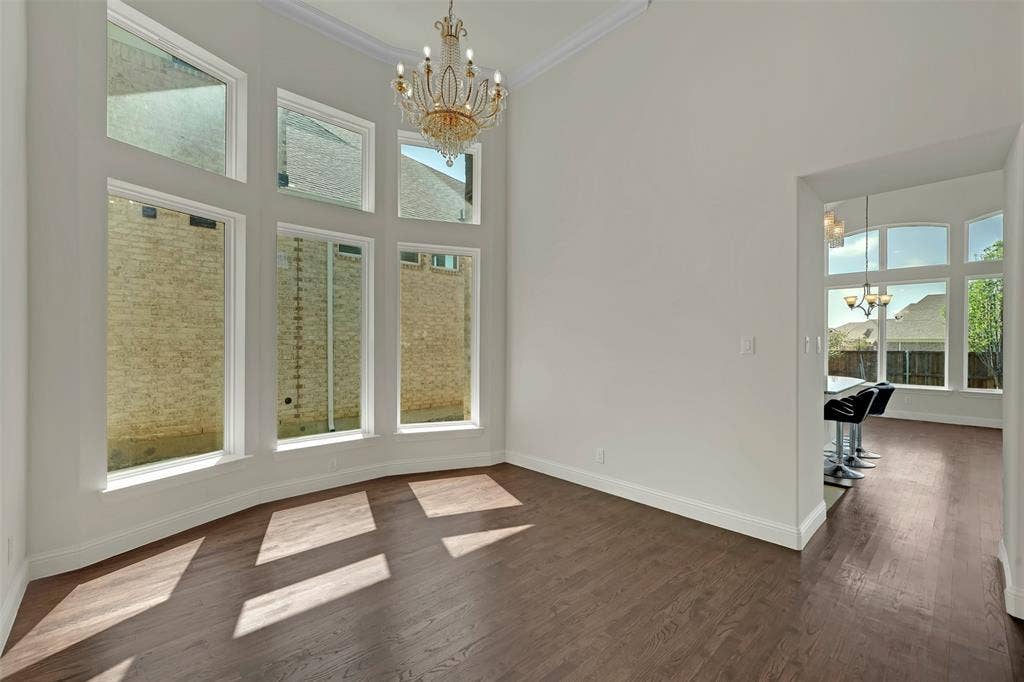 302 Torch Lily Lane, Wylie, TX 75098 High ceilings with crown molding, wood-finish flooring, and a multi-tiered crystal chandelier