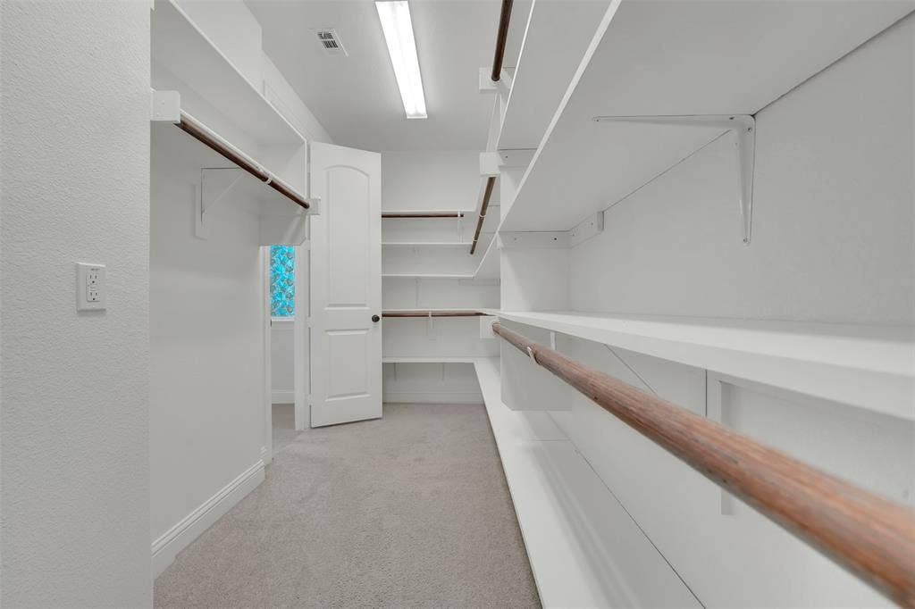 302 Torch Lily Lane, Wylie, TX 75098 Walk-in closet featuring extensive built-in shelving, multiple hanging rods, and recessed lighting