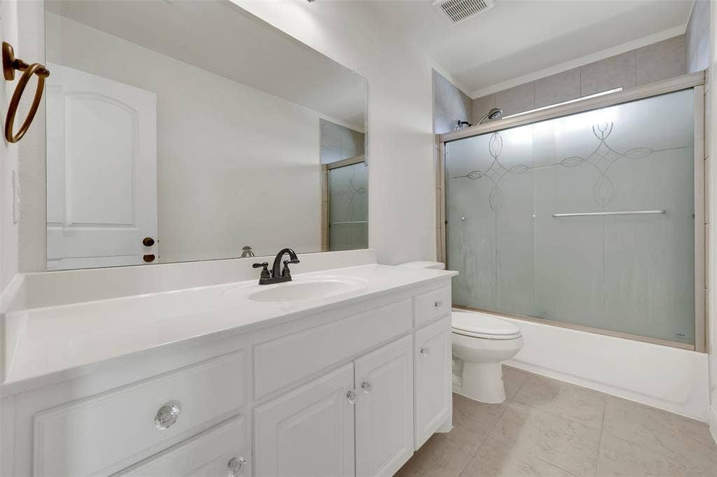 302 Torch Lily Lane, Wylie, TX 75098 White vanity with clear knob hardware, integrated sink, and dark bronze faucet