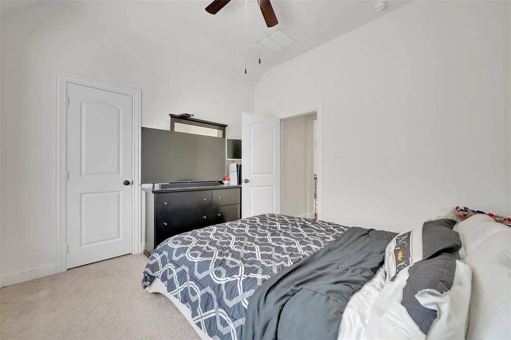 302 Torch Lily Lane, Wylie, TX 75098 Vaulted ceiling with a ceiling fan, white paneled doors, and light-toned carpet flooring