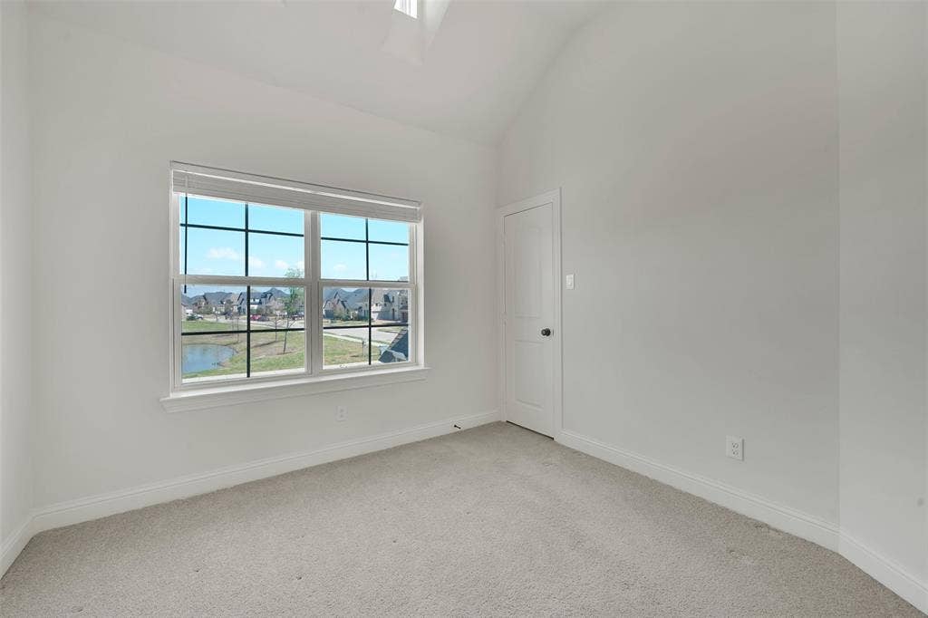 302 Torch Lily Lane, Wylie, TX 75098 Carpeted room with vaulted ceiling and a window featuring horizontal blinds