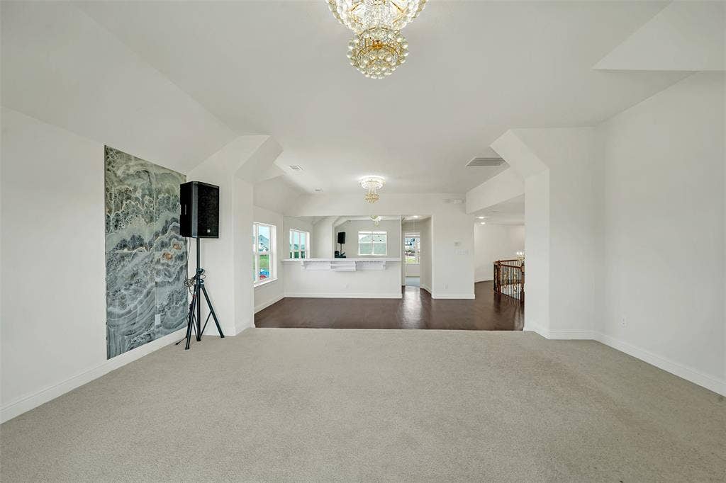 302 Torch Lily Lane, Wylie, TX 75098 Recessed ceiling detail with an ornate chandelier, neutral carpeting, and a built-in bar with a countertop