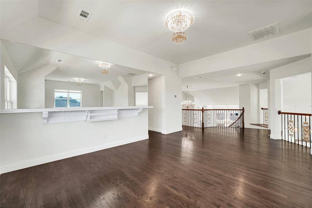302 Torch Lily Lane, Wylie, TX 75098 Dark wood-finish flooring, white walls, built-in mirrored wall, and wrought iron balusters