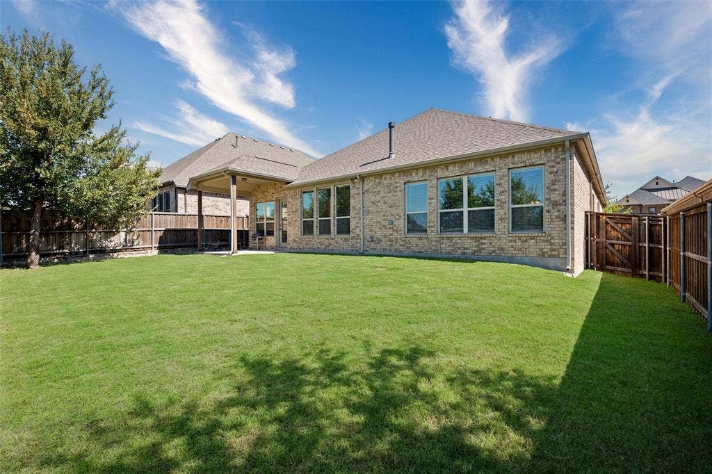 7601 Calhoun Cove, McKinney, TX 75071 Expansive backyard featuring a manicured lawn, full privacy fencing, and a covered patio