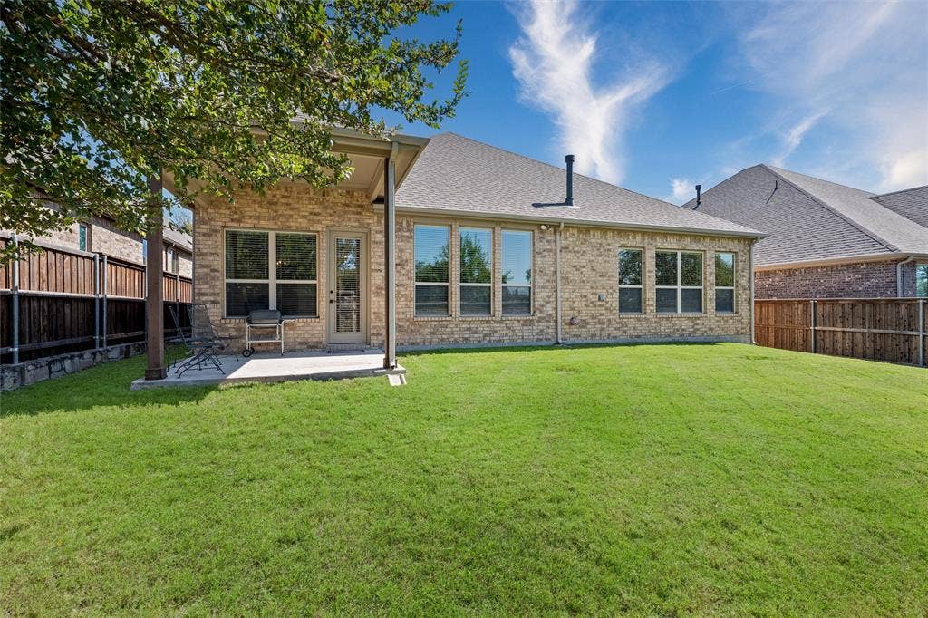7601 Calhoun Cove, McKinney, TX 75071 Expansive green lawn with a covered patio, brick exterior, and multiple windows