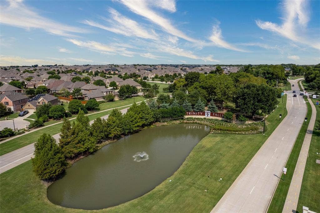7601 Calhoun Cove, McKinney, TX 75071 Residential community with an expansive green space, a decorative water feature, and mature trees