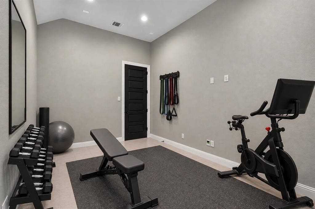 7601 Calhoun Cove, McKinney, TX 75071 Vaulted ceiling with recessed lighting, light-toned flooring, textured wall finish, and a paneled black interior door