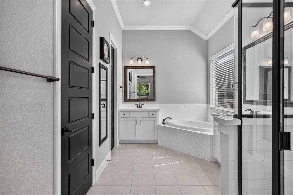 7601 Calhoun Cove, McKinney, TX 75071 Recessed lighting, wood-finish vanity with countertop, framed mirror, built-in bathtub, and a glass-enclosed shower