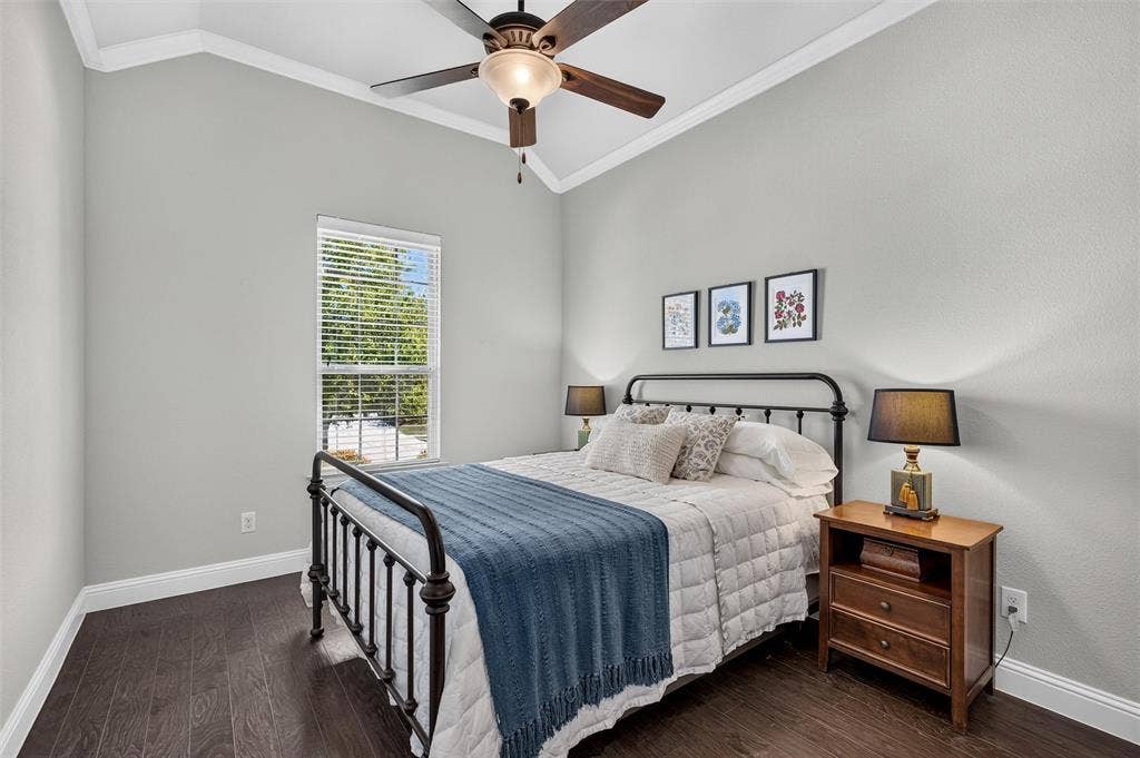 7601 Calhoun Cove, McKinney, TX 75071 Vaulted ceiling with crown molding, ceiling fan, wood-finish flooring, and a single window with blinds