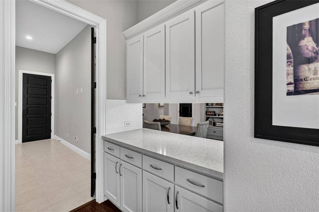 7601 Calhoun Cove, McKinney, TX 75071 White shaker cabinetry with polished nickel hardware, light-toned countertop, and white subway tile backsplash