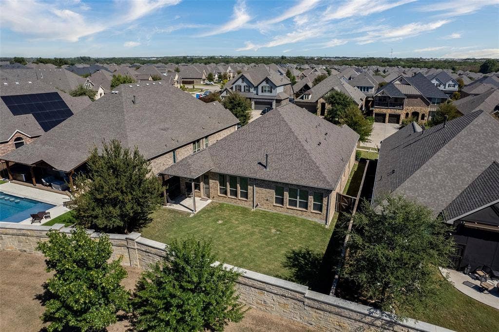 7601 Calhoun Cove, McKinney, TX 75071 Expansive backyard featuring a manicured lawn, a swimming pool, and a covered patio area