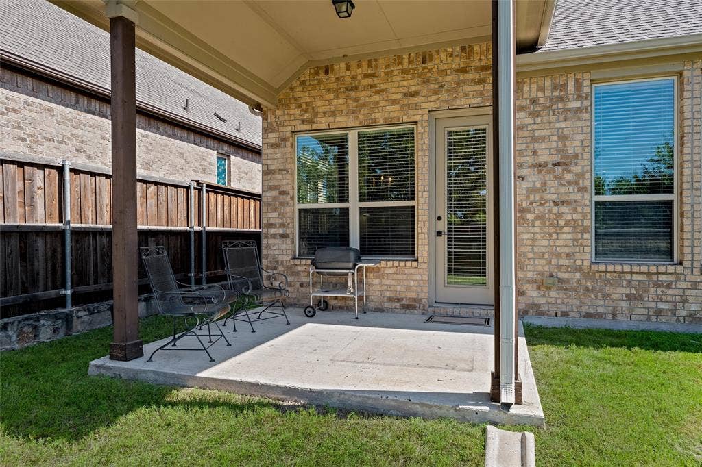7601 Calhoun Cove, McKinney, TX 75071 Covered patio with a concrete slab, brick exterior, and a privacy fence