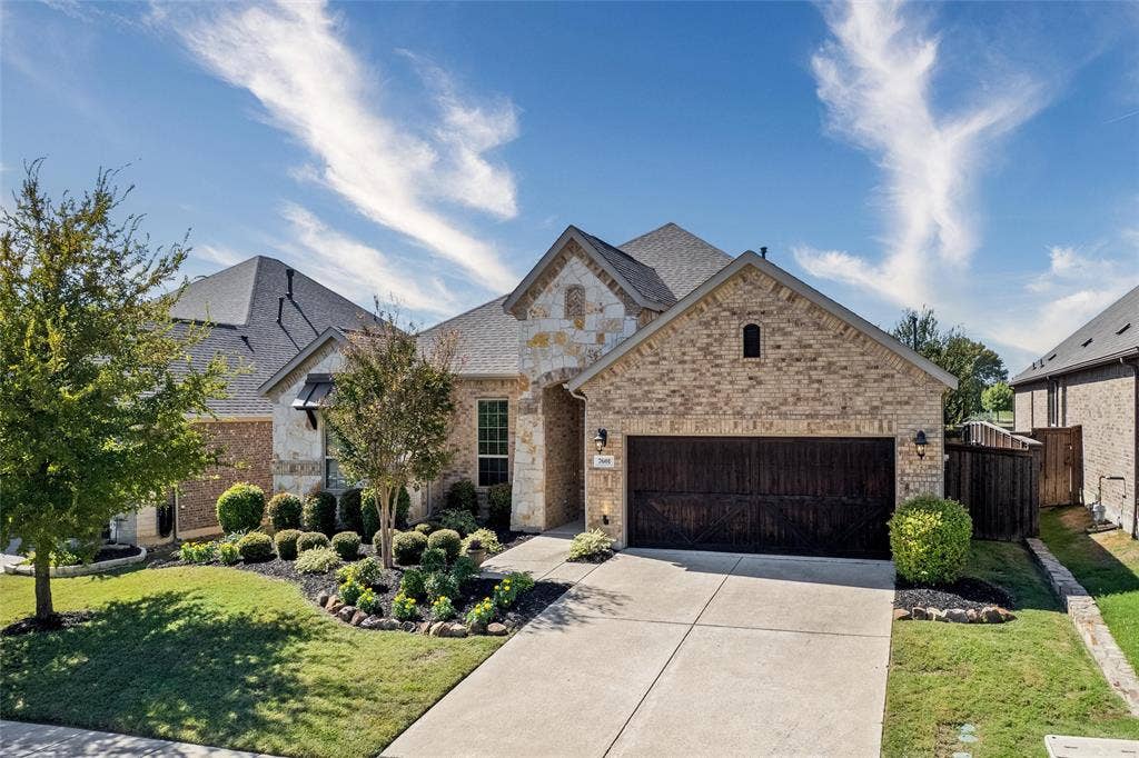 7601 Calhoun Cove, McKinney, TX 75071 Brick and stone exterior with an attached garage, concrete driveway, and established front landscaping