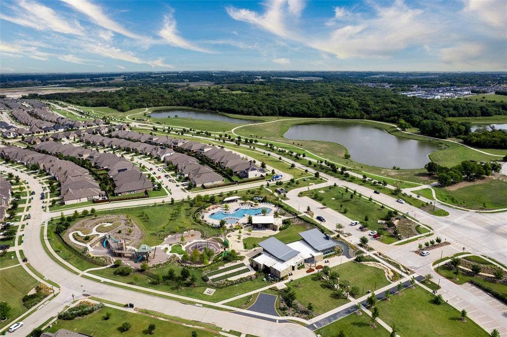 7601 Calhoun Cove, McKinney, TX 75071 Aerial perspective showcasing the community layout with residential properties, a large central park, a swimming pool, and natural water features