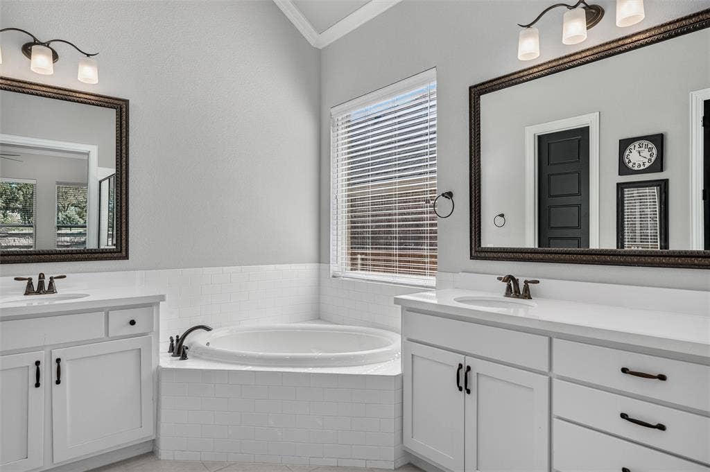 7601 Calhoun Cove, McKinney, TX 75071 Dual vanity with undermount sinks, white cabinetry, a built-in soaking tub, and subway tile surround