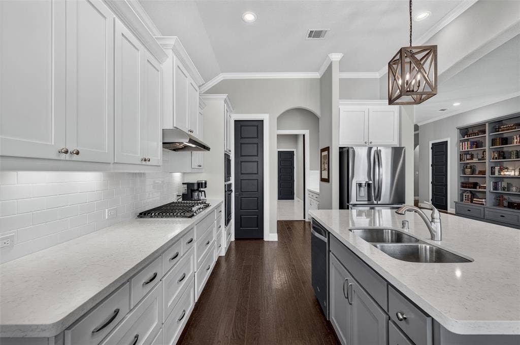7601 Calhoun Cove, McKinney, TX 75071 Gourmet kitchen with white upper cabinetry, gray lower cabinetry, light countertops, subway tile backsplash, and dark wood-finish flooring