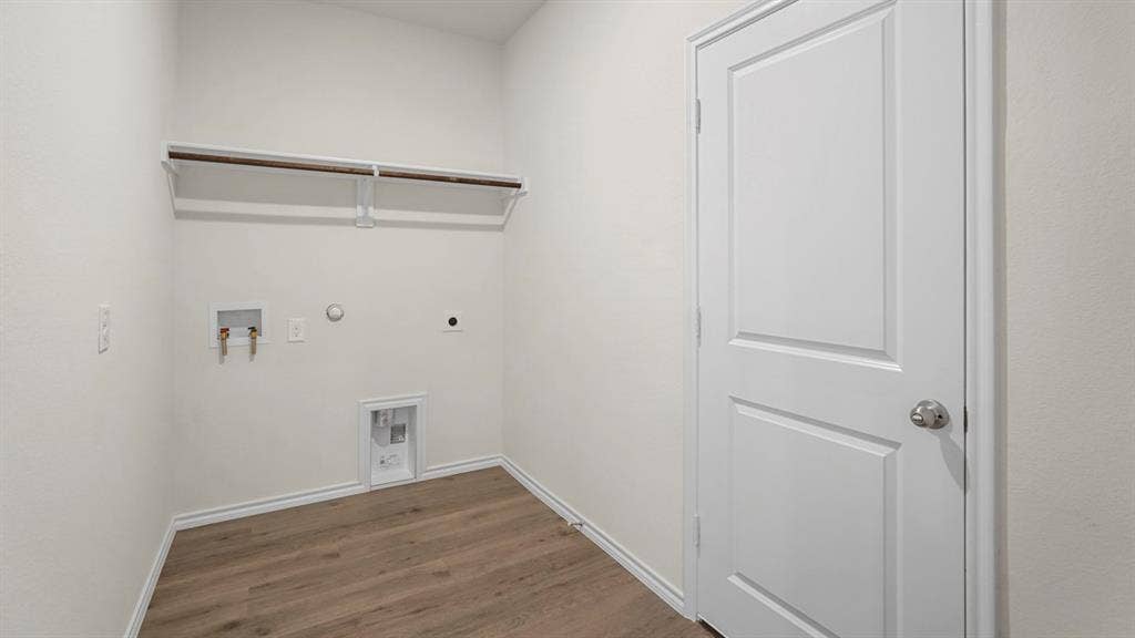 1671 Blaire Drive, Tyler, TX 75702 Utility room featuring wood-finish flooring, white walls, and a clothes hanging rod