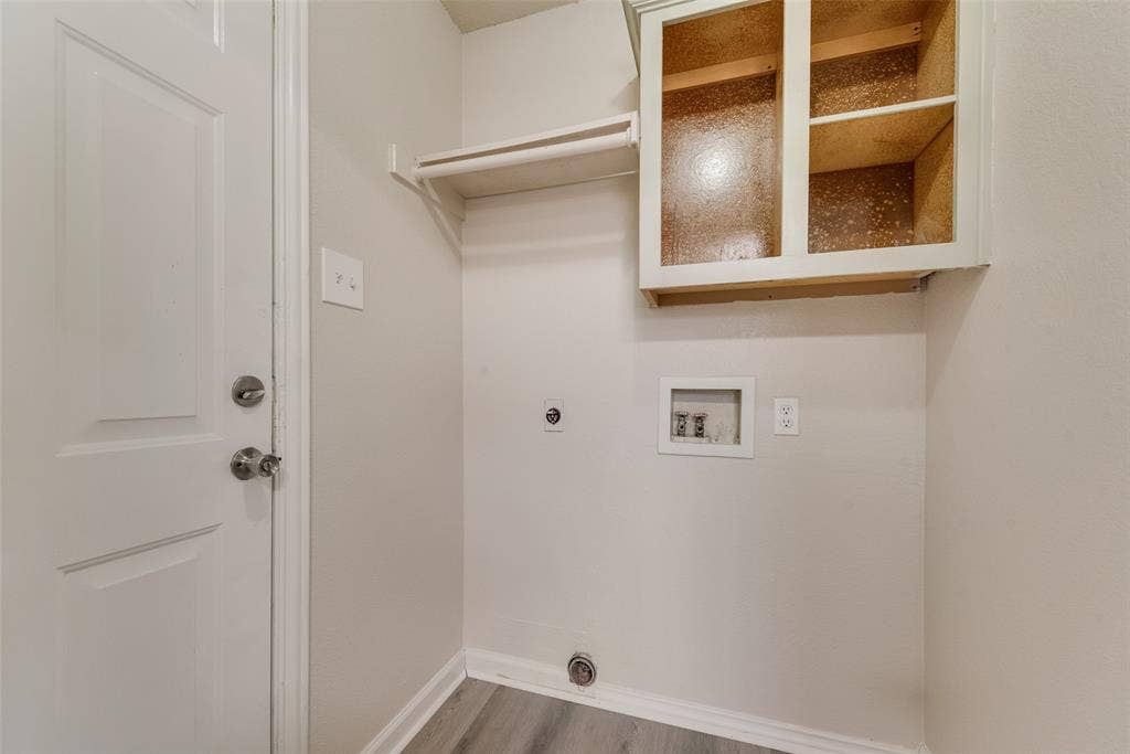 220 Hollywood Drive, Glenn Heights, TX 75154 Laundry area with wood-finish flooring, overhead shelving, and built-in cabinetry