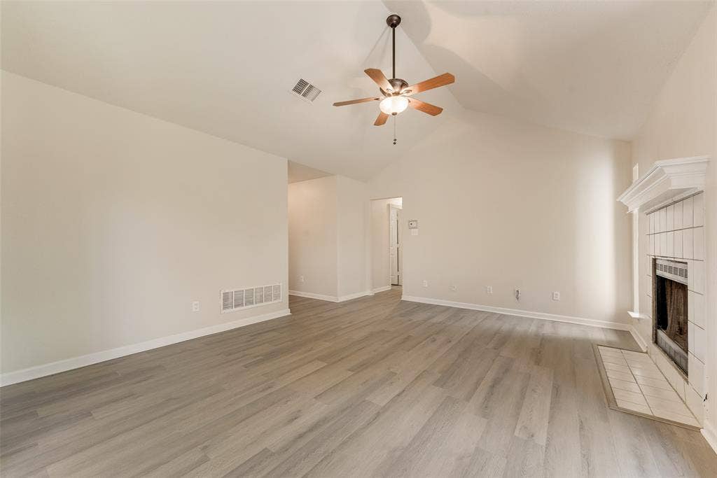 220 Hollywood Drive, Glenn Heights, TX 75154 Vaulted ceiling, wood-finish flooring, white tiled fireplace with mantel, ceiling fan with integrated lighting