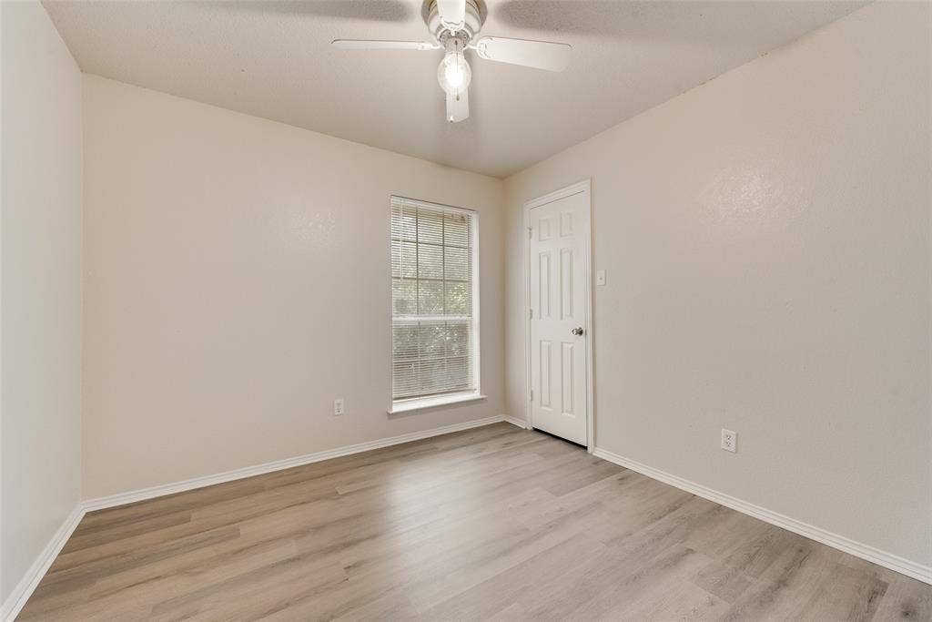 220 Hollywood Drive, Glenn Heights, TX 75154 Wood-finish flooring, single window, paneled door, and a ceiling fan with light fixture