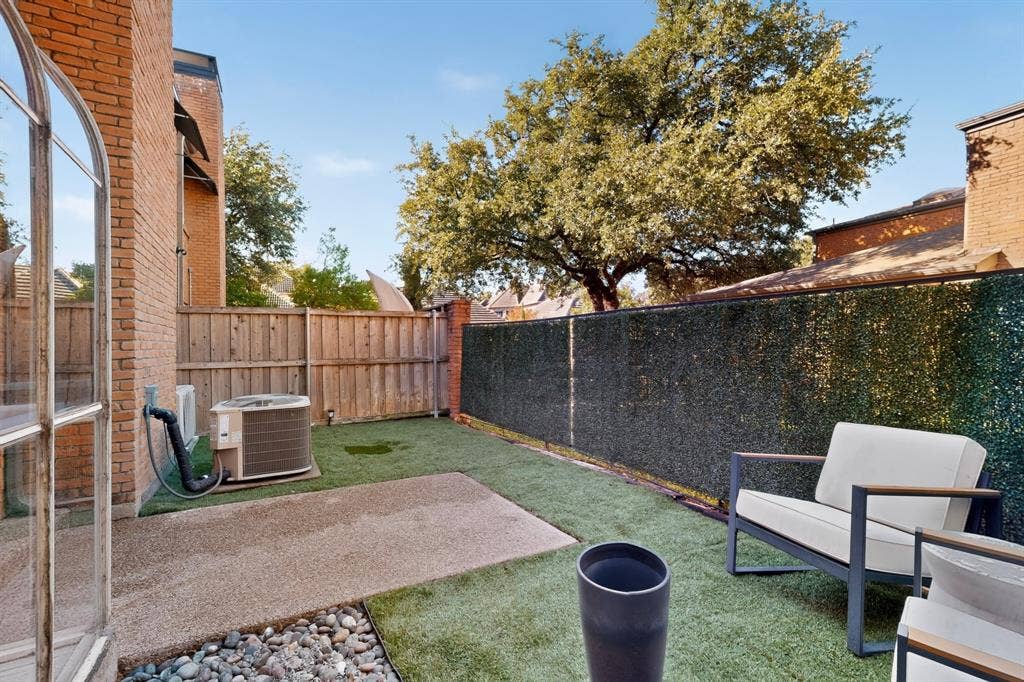 17335 Remington Park Place, Dallas, TX 75252 Private exterior space featuring artificial turf, a paved patio, and a stone-lined border