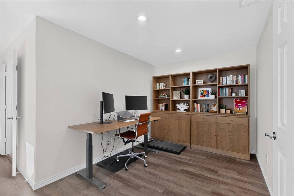 17335 Remington Park Place, Dallas, TX 75252 Wood-finish flooring, recessed lighting, built-in shelving with integrated cabinetry, and painted white trim