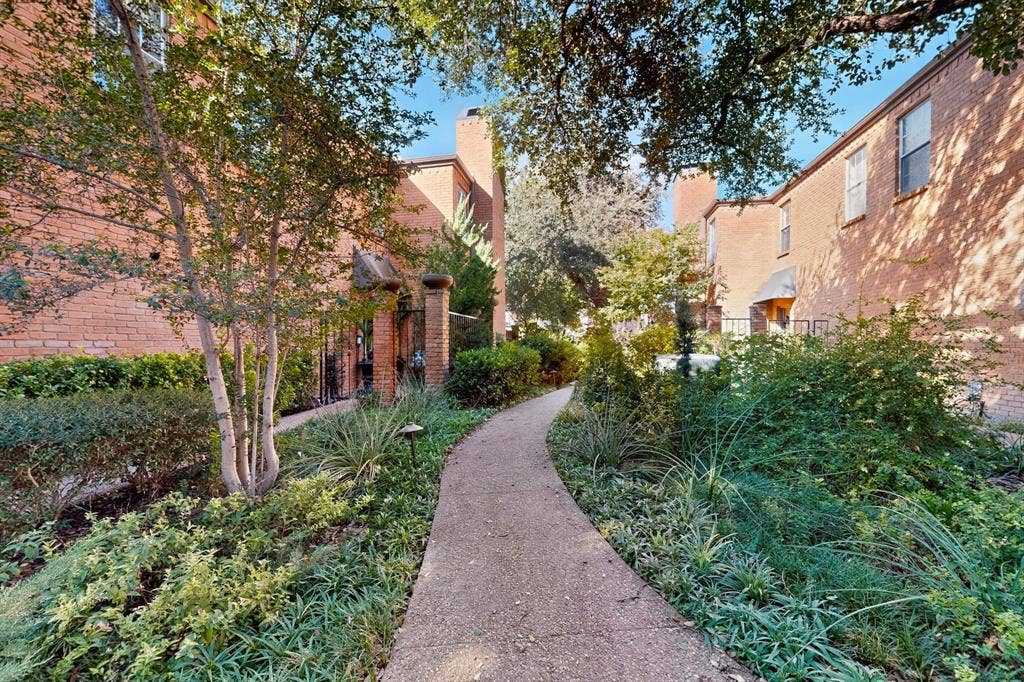 17335 Remington Park Place, Dallas, TX 75252 Curved concrete pathway with varied plantings, brick building exteriors, and mature trees