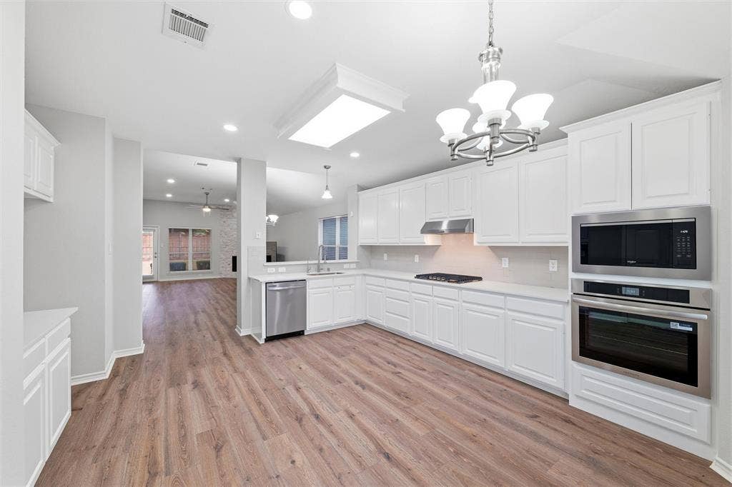 The updated kitchen featuring ample cabinetry, gas cooktop, built-in oven and microwave, and a clean, timeless color palette.