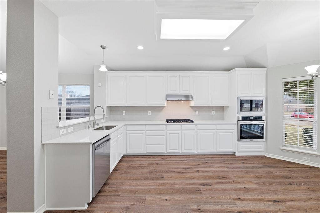 Enjoy easier meal prep in this bright, updated kitchen featuring a gas cooktop, built-in oven and microwave, updated hardware, and clean, contemporary finishes throughout.