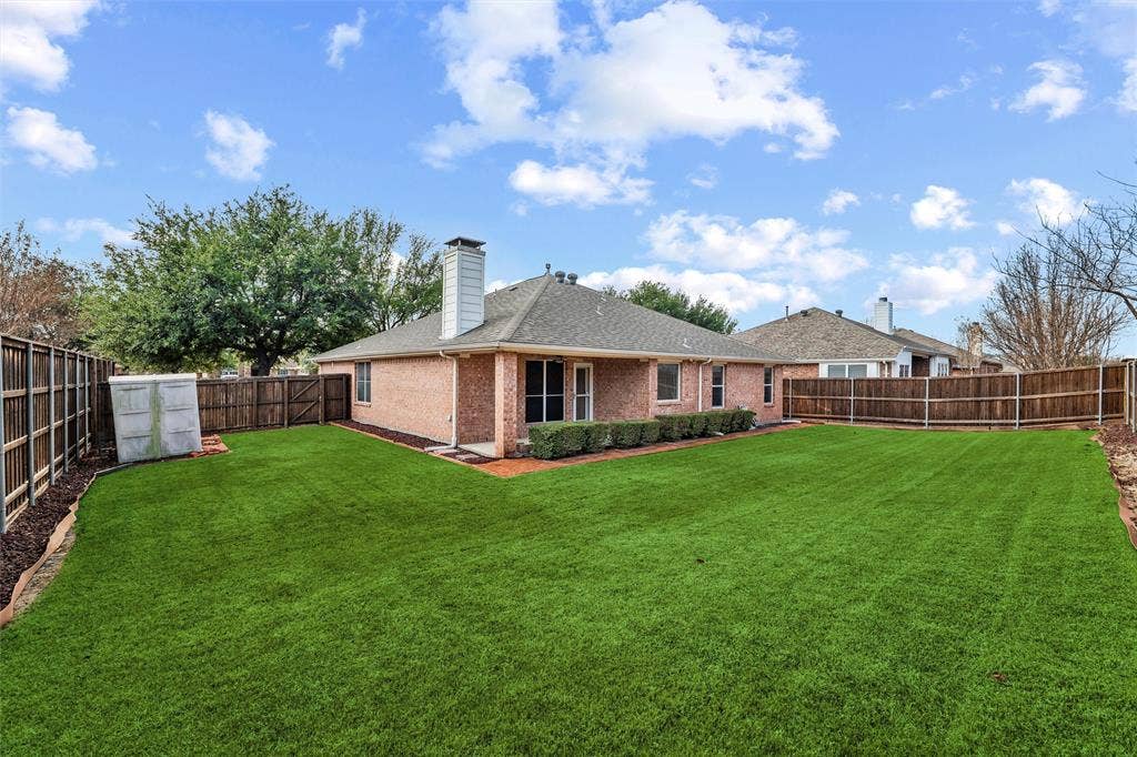 Professionally landscaped backyard offering plenty of green space for outdoor activities, play, or pets.