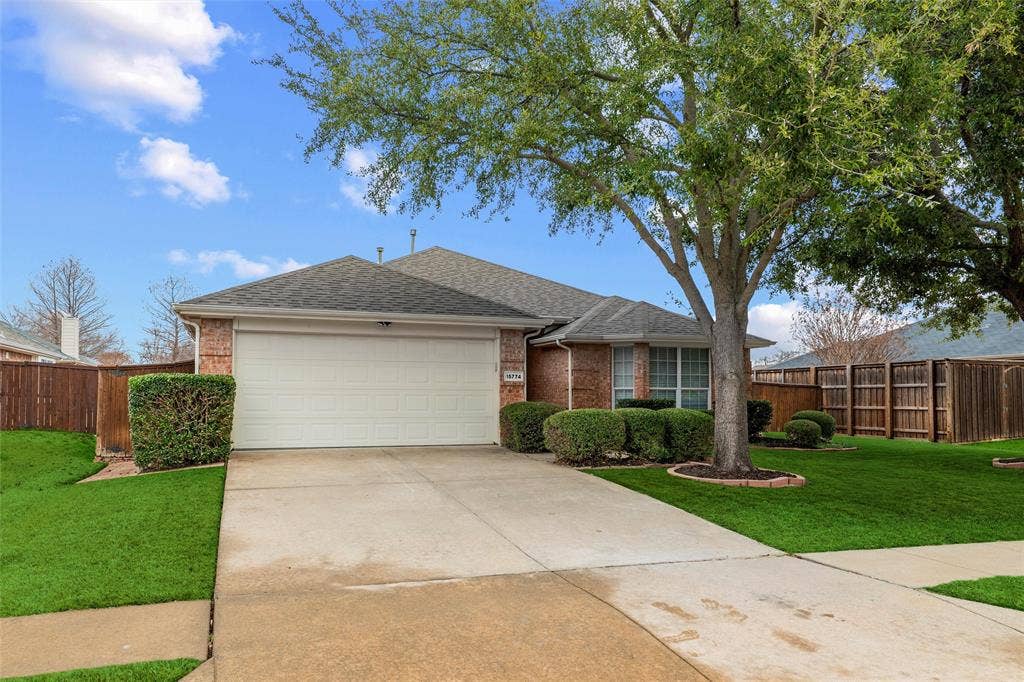 Attractive brick exterior with mature landscaping, a full two-car garage, and a well-maintained front lawn offering strong curb appeal.