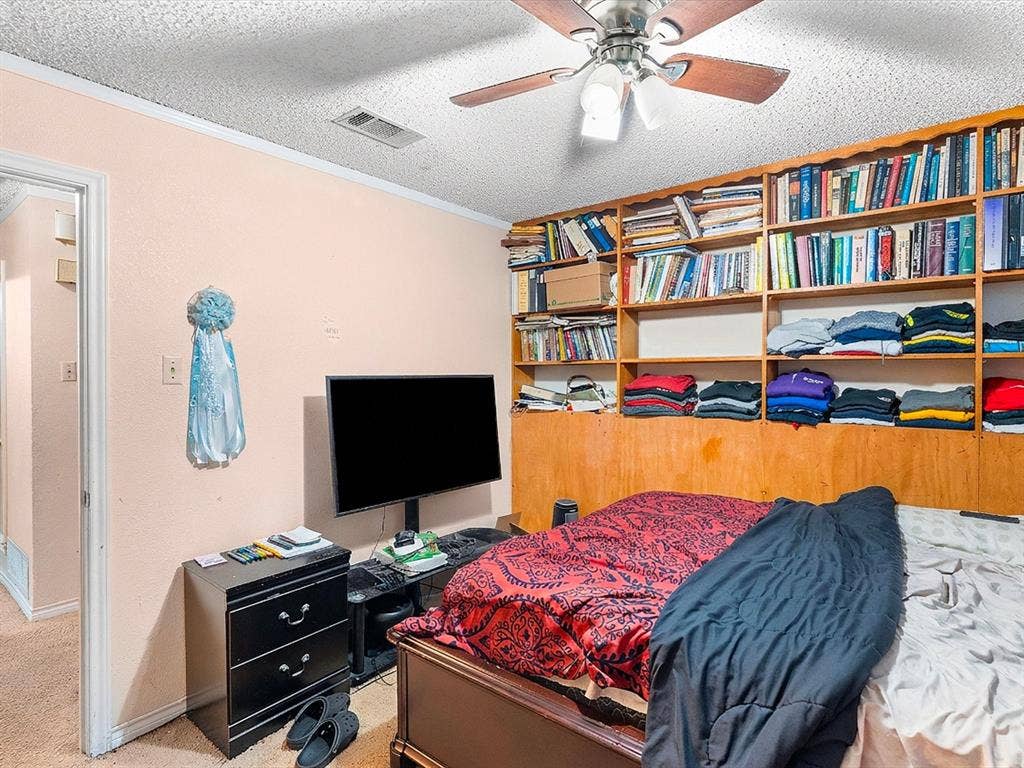 5818 Winding Woods Trail, Dallas, TX 75227 Integrated wall-to-wall shelving with wood paneling, ceiling fan with light fixture