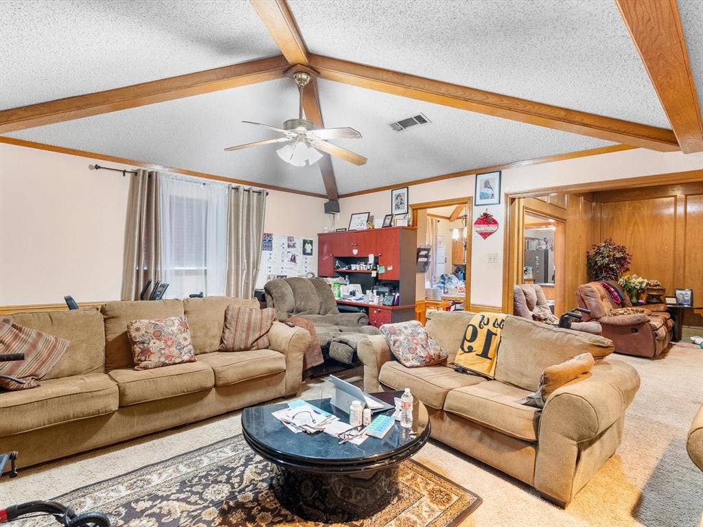 5818 Winding Woods Trail, Dallas, TX 75227 Beamed ceiling, ceiling fan, wood-paneled accent wall, and window with curtains
