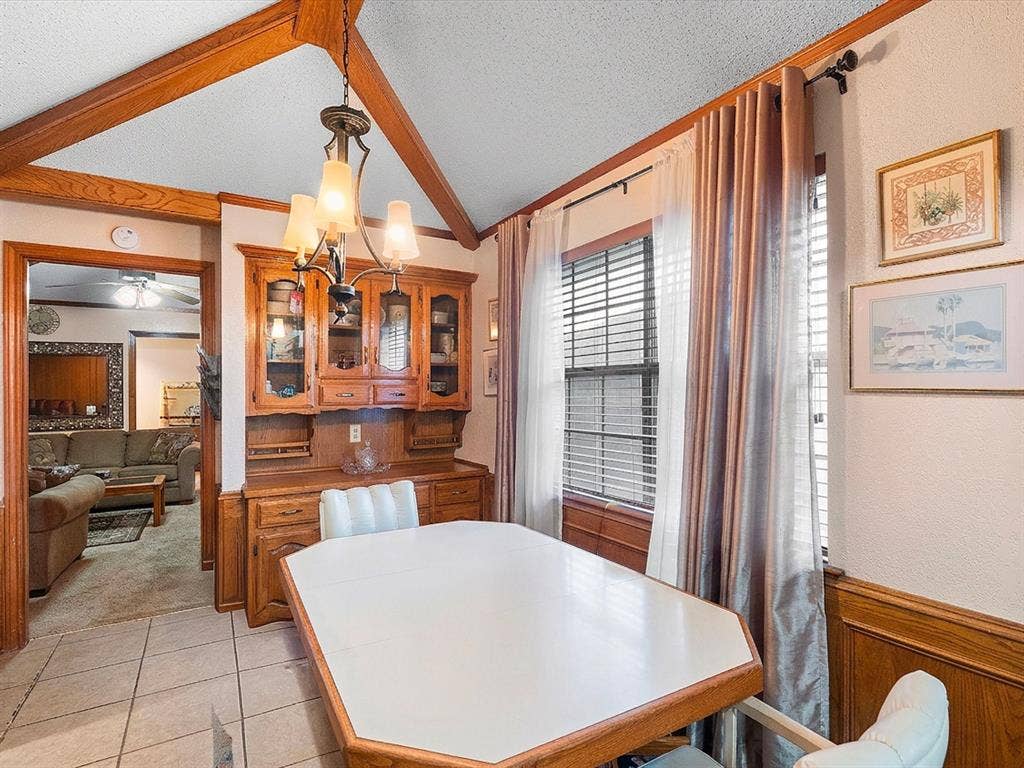 5818 Winding Woods Trail, Dallas, TX 75227 Vaulted ceiling with wood beams, tiled flooring, wood wainscoting, and a built-in wood hutch with glass-front cabinets