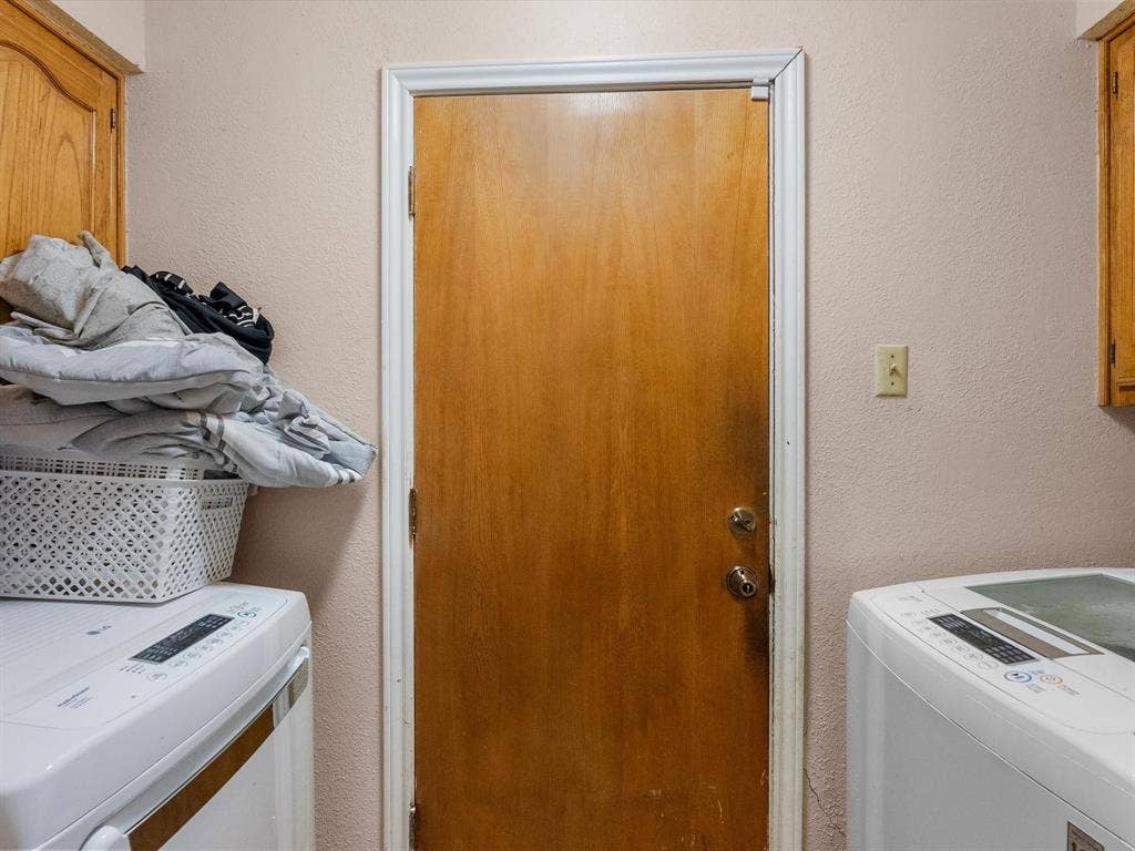 5818 Winding Woods Trail, Dallas, TX 75227 Full size washer and dryer area with cabinetry.
