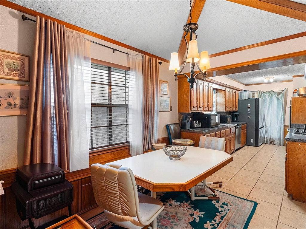 5818 Winding Woods Trail, Dallas, TX 75227 Wood-finish ceiling beams, an ornamental chandelier, and wood-paneled walls