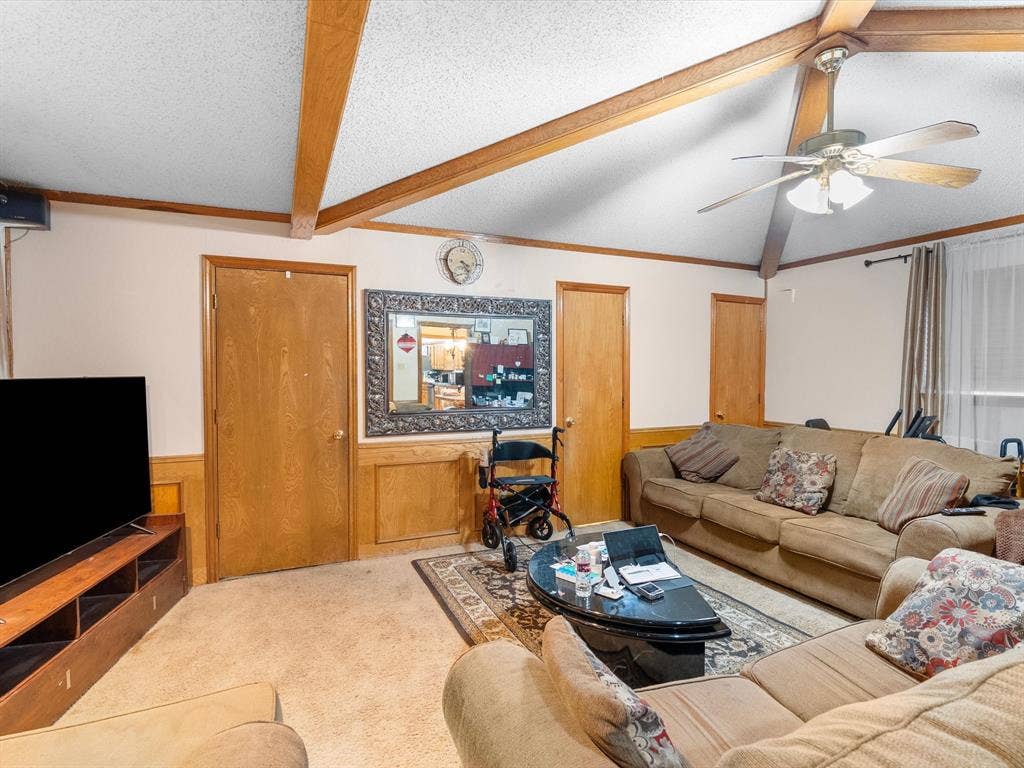 5818 Winding Woods Trail, Dallas, TX 75227 Vaulted ceiling with exposed wood beams, wood-finish doors, and wainscoting