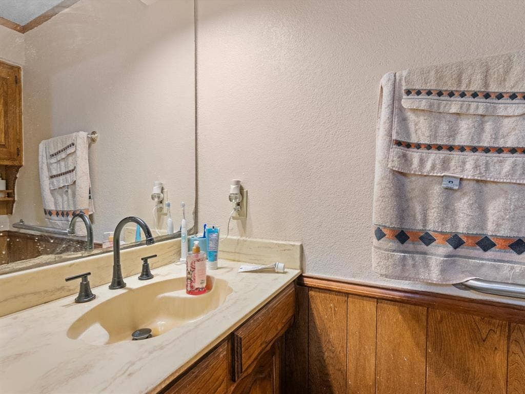 5818 Winding Woods Trail, Dallas, TX 75227 Half bath. Vanity with an integrated sink, dark bronze-finish faucet, and coordinating dark bronze-finish knob handles