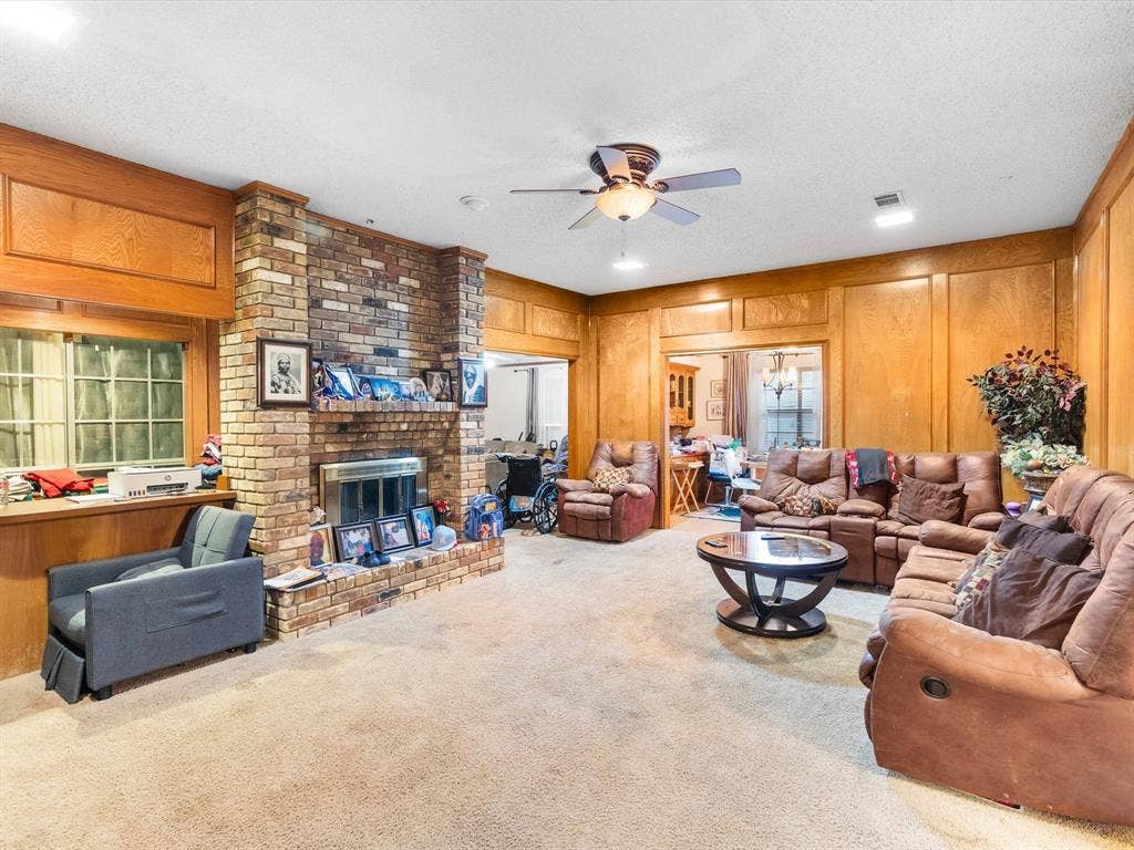 5818 Winding Woods Trail, Dallas, TX 75227 Brick fireplace with hearth, wood-paneled walls, ceiling fan with integrated lighting, wet bar by the fireplace.