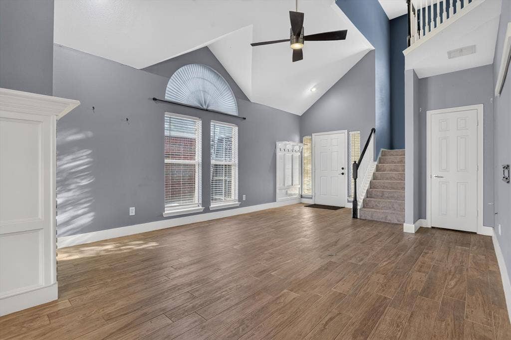 1825 Bachman Court, Plano, TX 75075 Vaulted ceilings with an arched transom window, wood-finish flooring, and a ceiling fan with integrated lighting