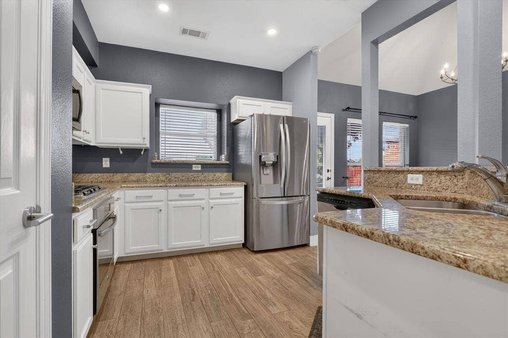 1825 Bachman Court, Plano, TX 75075 Kitchen featuring white cabinetry, stone countertops, stainless steel appliances, and wood-finish flooring