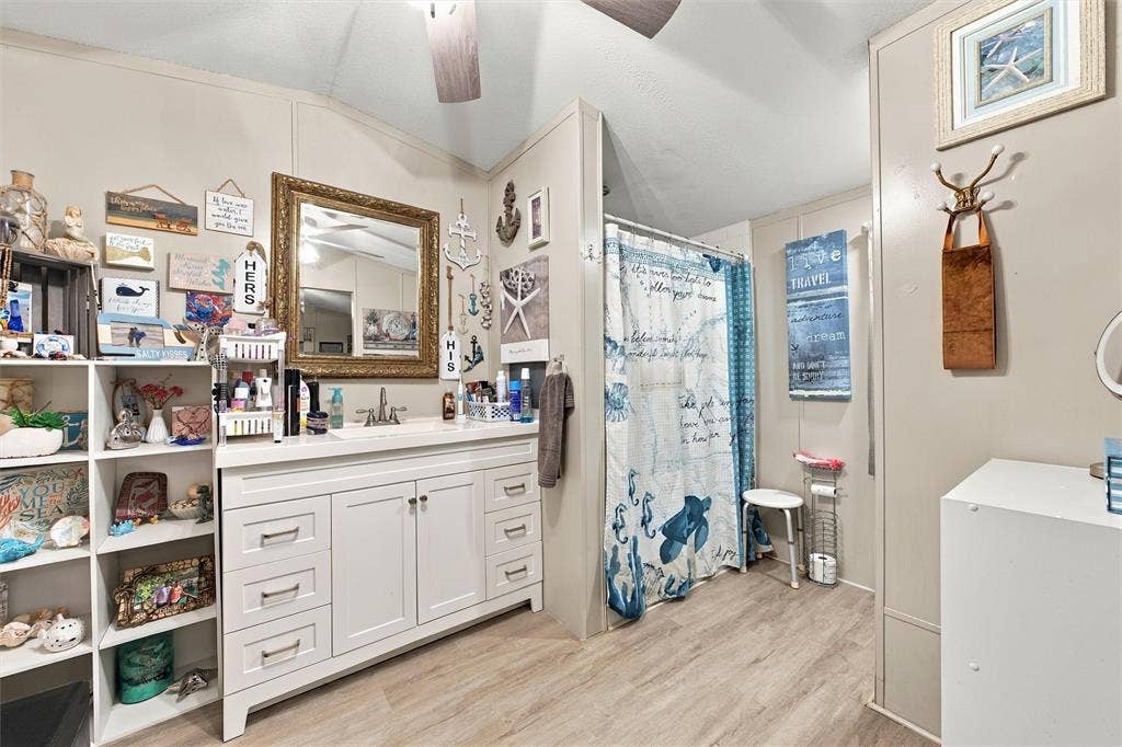 365 Beaver Lane, Waco, TX 76705 White vanity with multiple drawers and cabinet storage, single basin sink, and a framed mirror