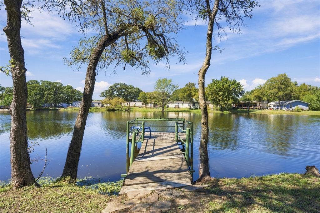 365 Beaver Lane, Waco, TX 76705 Private dock with wood planking and green railings, situated on a tranquil body of water